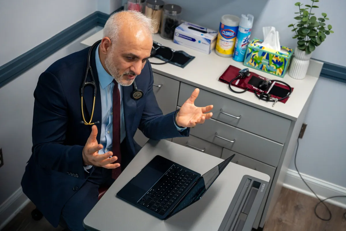 Dr. Suresh Malik explaining results at a laptop in a Quality Primary Care Associates exam room