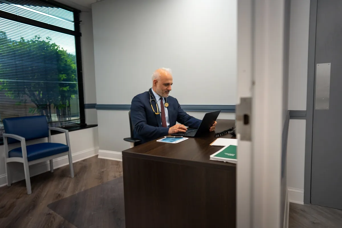 A consultation office at Quality Primary Care Associates seen through the open door
